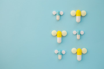 penis symbol made out of medical yellow and blue capsules and wh