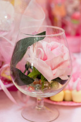 Artificial rose in a glass goblet
