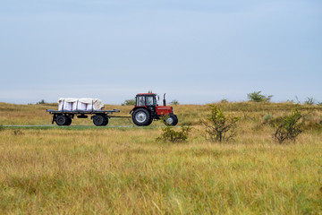 Red tractor in open field going right