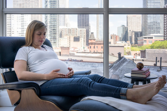 Pregnant woman relaxing on armchair