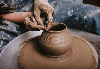 Hands working on pottery wheel