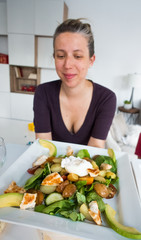 Woman holding plate of fresh salad