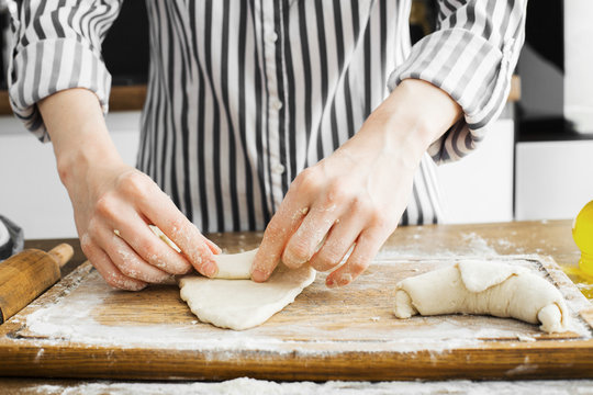 Female hands making dough on kitchen background
