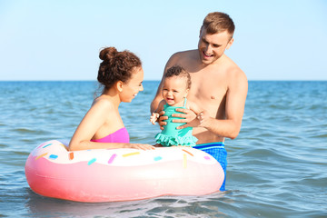 Obraz premium Family with inflatable ring in sea at resort