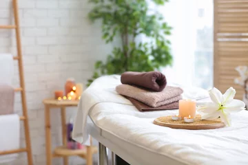 Fotobehang Towels, candles and flower on massage table in spa salon © New Africa
