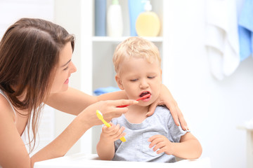 Obraz na płótnie Canvas Mother teaching her child how to clean teeth