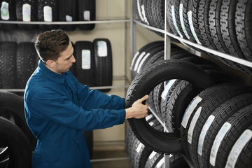 Young male mechanic with car tires in automobile service center © New Africa