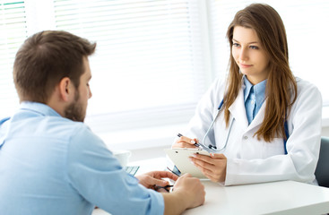 Doctor writes out the pills to the patient