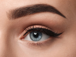 Obraz premium Eye of young woman with beautiful eyebrow after correction, closeup