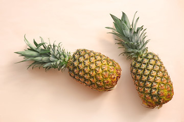 Fresh ripe pineapples on color background, top view