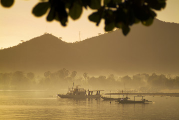 Obraz premium Balinese Fishing Boats Anchored in the Village of Pemuteran. Balinese fishing boats, called jukung, in the bay of northwest Bali, Indonesia during a beautiful sunrise. 