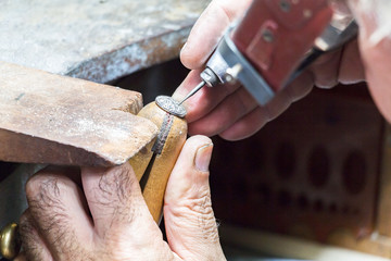 Jeweler engraving diamonds on a ring.