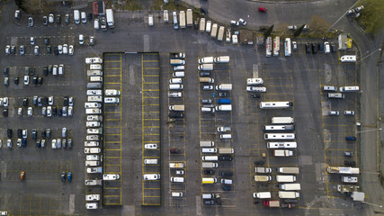Aerial view of a large parking lot for cars, trucks, motorcycles and caravans. The lines of the parking lots are yellow and there are still many free places on the asphalt.