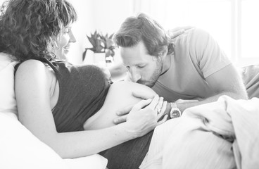Husband kissing a baby bump