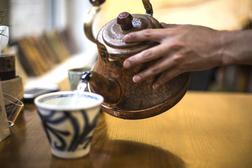 kettle pouring boiling water into a cup in cafe