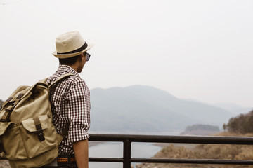 Young man tourist see view of mountain on bridge.