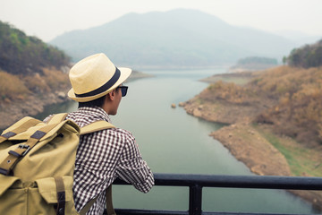 Obraz premium Young man tourist see view of mountain on bridge.