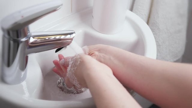 Woman wash hands in bathroom