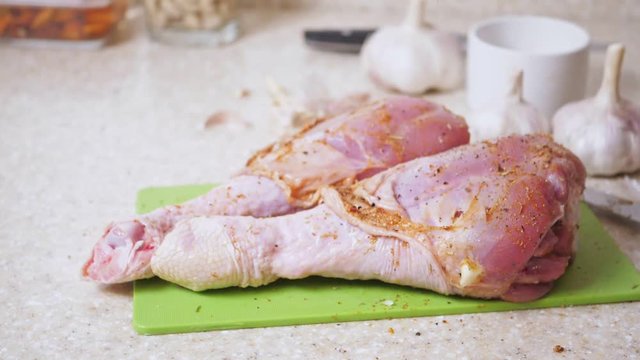 Falling down dressing herbs on uncooked turkey legs at the kitchen