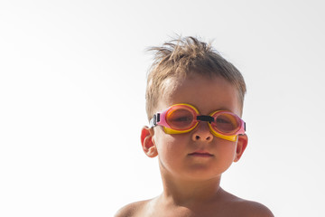 Little boy in swimming goggles on the beach