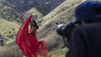 photographer photographing a young woman dancing on a mountain