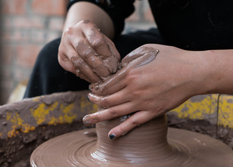 hands of a potter, creating an earthen jar on the circle
