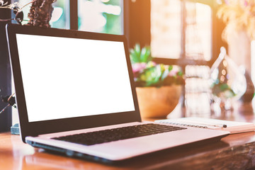 Mockup image of laptop with blank white screen on wooden table of In the coffee shop.