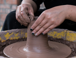 hands of a potter, creating an earthen jar on the circle