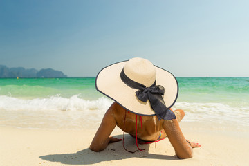 Fototapeta na wymiar Woman with a straw hat at the beach in Koh Poda island Thailand