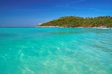 Beautiful seascape. Mountains, jungle and sea. Turquoise clear water, bright blue sky in bay. Tranquil waters, vacation wallpaper.