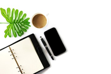 Flat Lay photo with Notebook ,Cell phone.Coffee cup , Pen and Tropical Leaf on White Color background.copy space