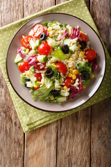 Italian vegetable salad with orozo pasta close-up on a plate. Vertical top view from above