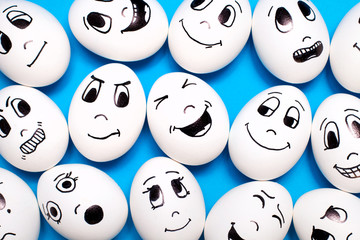 Texture of eggs with drawn cartoon faces with various emotions