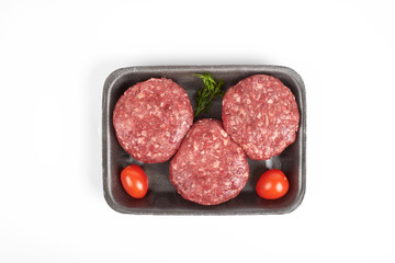 Tray with raw beef burgers or minced meat isolated on white background