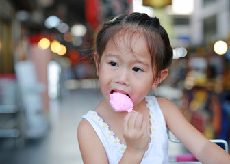Little asian child girl eating ice-cream.
