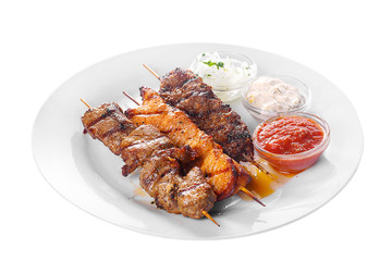 Shish kebab, beef, lamb, pork, chicken meat on the grill, barbecue, without garnish on a plate, isolated on white background. Marinated onion, mayonnaise, tar tar, ketchup, tomato sauce Side view