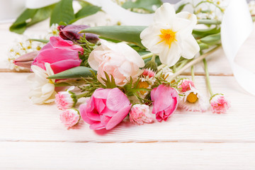Festive flower pink, white anemones, tulips, daffodils, daisies composition on white wooden desk, background. Overhead top view, flat lay. Copy space. Birthday, Mother's, Women's, Wedding Day concept