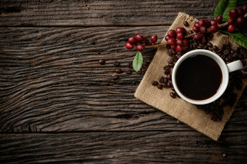 Top view mockup a cup of coffee with red ripe coffee beans.