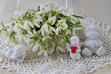 in a white basket a lot of snowdrops, angels and hearts - holiday background