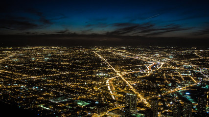 Night city lights in suburbs. Dark night skyline, city lights fill all the streets and highways, roads like veins last through the entire picture..