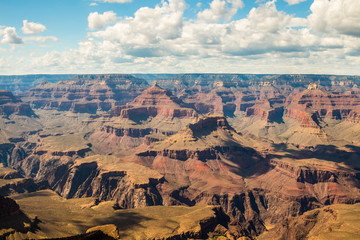 Skyline above the grand canyon. Beautiful Grand Canyon shapes under the sunny sky with shadows falling down from the clouds. 