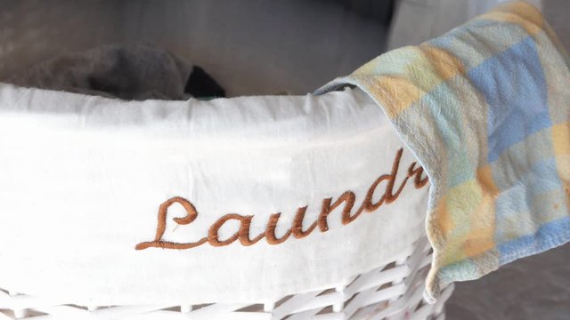 putting clothes in the laundry basket