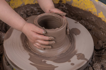hands of a potter, creating an earthen jar on the circle
