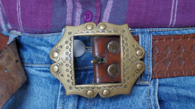 unfastening the belt on trousers, decorative buckle