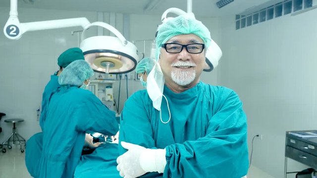 Senior doctor looking to camera with smiling at operation room. Healthcare and Medical concept. 