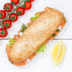 Sandwich Baguette Vollkorn Brötchen belegt mit Lachs Fisch Quadrat von oben auf Holzbrett