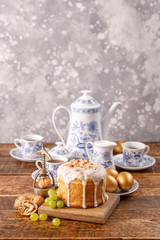 Vertical easter still life. A festive table with a home Easter cake, an ancient tea or coffee service and golden eggs. Easter card with a place under your text. Beautiful postcard.