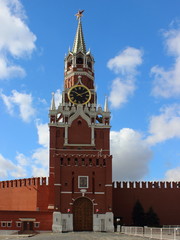 Fototapeta na wymiar Spasskaya tower of the Kremlin on red square in Moscow (Russia) in summer against a blue cloudy sky