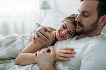 Fototapeta premium Portrait of young loving couple in bedroom