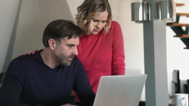 Couple looking worried at Laptop at Home